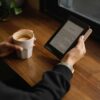 Reading on a Kindle over morning coffee by a window