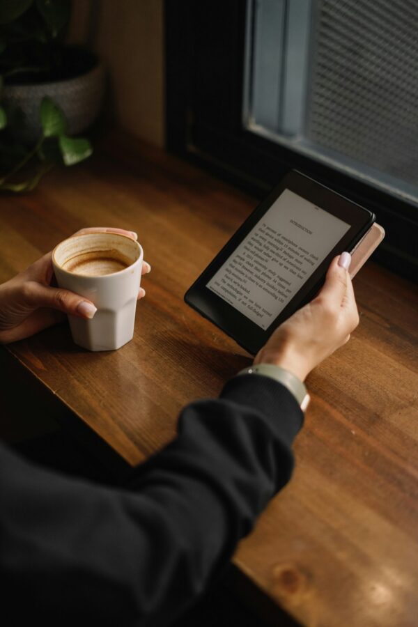 Reading on a Kindle over morning coffee by a window